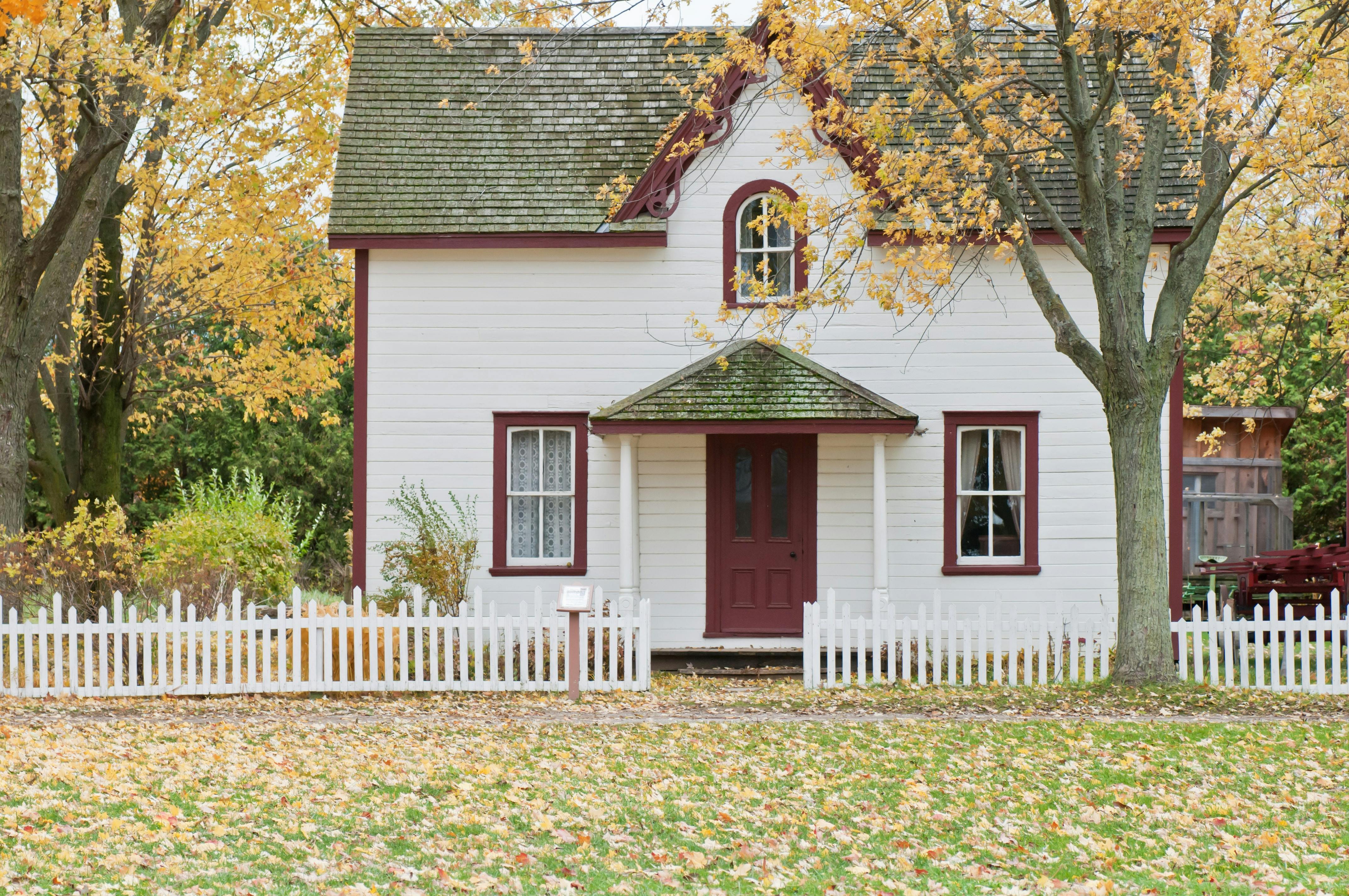 Photo of two-story house with white picket fence